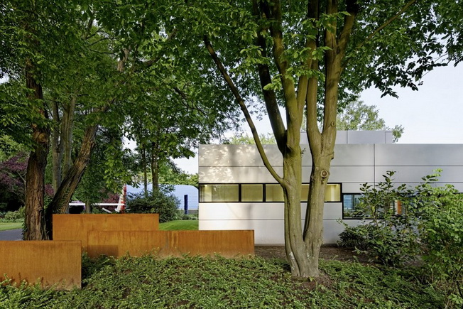 Jednopiętrowy dom w formie sześcianów z metalową fasadą